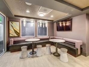 Un intérieur moderne avec un espace salon, des tables rondes et une grande fenêtre.