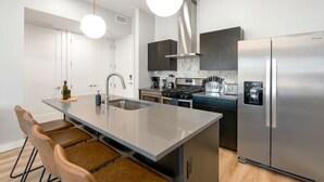 Eine moderne Küche mit einer zentralen Kochinsel, Edelstahlgeräten und einem minimalistischen Design.
