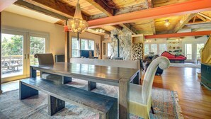 A spacious living area with a large wooden table, benches, and a stone fireplace. - Luxe 14-Acre Vermont Countryside Lodge! (Washington)