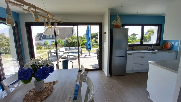 Een moderne keuken met een grote schuifdeur naar een terras.