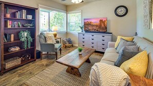 Ein gemütliches Wohnzimmer mit Bücherregal, einer Couch, einem Couchtisch und einem Fernseher.