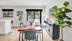 A modern kitchen with a dining area, a large window, and a view of the outdoors.