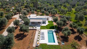 A modern house with a swimming pool, surrounded by olive trees and a clear sky. - 3419 Trullo Mest Marcucc by Perle di Puglia (San Michele Salentino)
