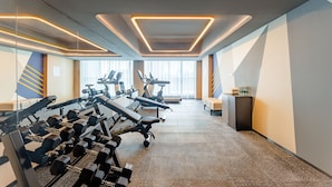 Un gimnasio moderno con equipamiento de ejercicio, ventanas amplias y un diseño limpio.