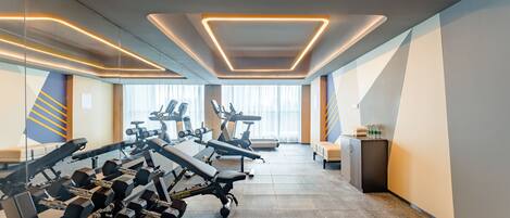 A modern gym with exercise equipment, large windows, and a clean design.