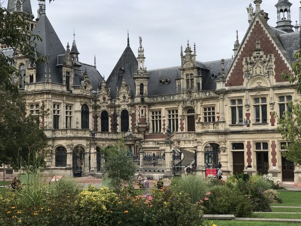 Un bâtiment historique à l’architecture riche et élaborée, avec notamment des toits en forme de flèche et des sculptures complexes en pierre.