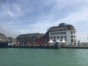 Un bâtiment situé au bord de l’eau, doté de plusieurs étages, d’un dôme imposant et d’une marquise rouge.
