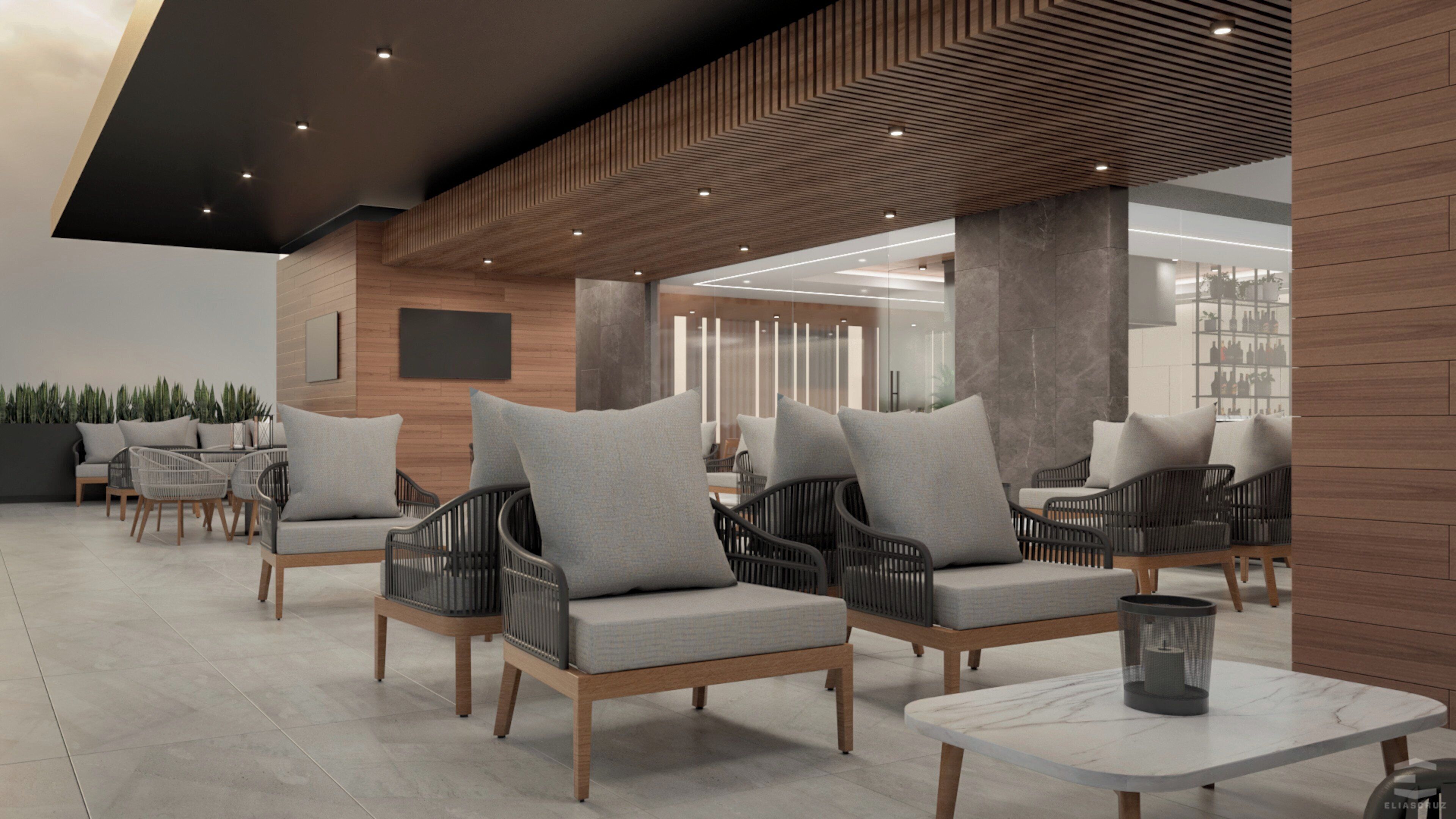 A modern lounge area with seating and tables, featuring a wooden ceiling and a view of the interior space.