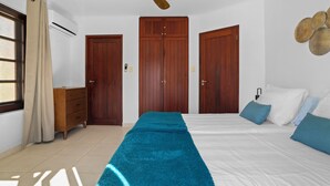 Une chambre à coucher avec un lit, une commode et deux armoires.