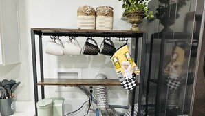 A kitchenette with a coffee maker, toaster, and a shelf with kitchen utensils and a plant. - Home sweet home in West Jordan (West Jordan)