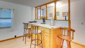 A kitchen with wooden cabinetry, a white countertop, and two bar stools. - Cozy Fort Cobb Home Rental Near Lake Access! (Fort Cobb)
