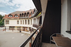 A building with a balcony, a wooden table, and a bench.