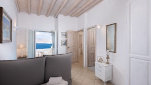 Una habitación con sofá, cómoda y vista al mar.