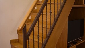 Una scala in legno con ringhiera in metallo nero, che conduce a un livello inferiore.