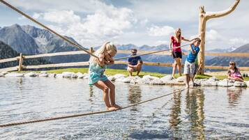 A rope bridge over a body of water with mountains in the background.