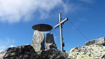 Paesaggio roccioso con una struttura metallica e una croce di legno.
