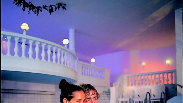 A couple in a swimming pool with a balustrade and lights in the background. - Hotel Alpina Resort nature & wellness (Wenns)