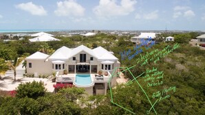 A large, two-story house with a swimming pool, a garden, and a gate/parking access. - CAICOSVERDE Amazing Garden 2 Bedrooms Suite with Living Room and Kitchenette. (Providenciales)
