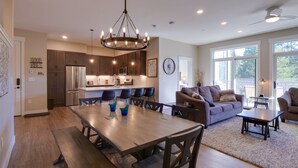A spacious kitchen with modern appliances, a dining area with a large table, and a cozy living room with a sofa and chairs. - Stunning Winter Park Condo Near Slopes! (Winter Park)