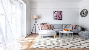 A modern living room with a sofa, a coffee table, and a painting on the wall.