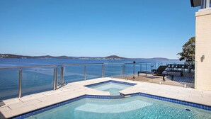 A pool area with a view of the sea, a deck with chairs, and a clear sky. - Stay 3 nights, pay 2 this Winter* (POINT CLARE)