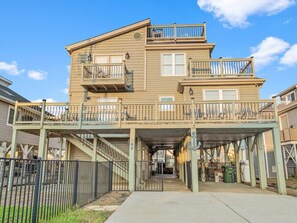 A two-story building with a covered walkway and a fenced area.