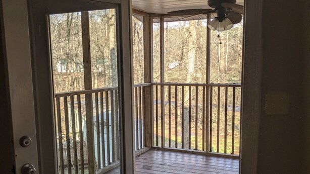 Ein Zimmer mit Holztür und einem Balkon mit Geländer.