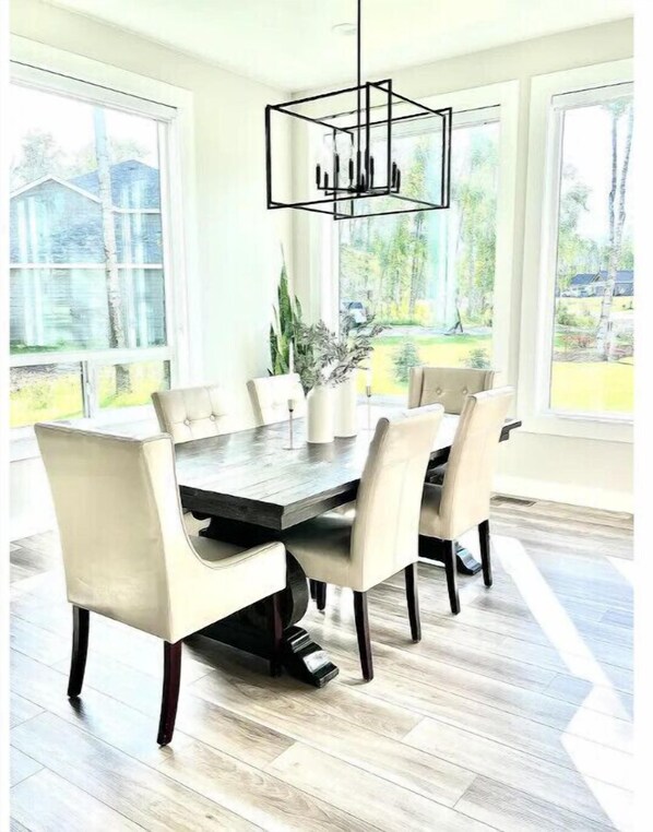 A dining area with a large table, six chairs, and a hanging light fixture. - Alaska Getaway Wasilla, Alaska (Wasilla)