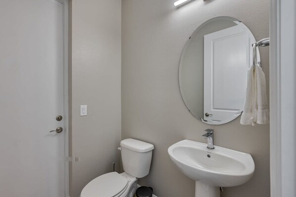 Un baño con inodoro, lavabo y espejo.