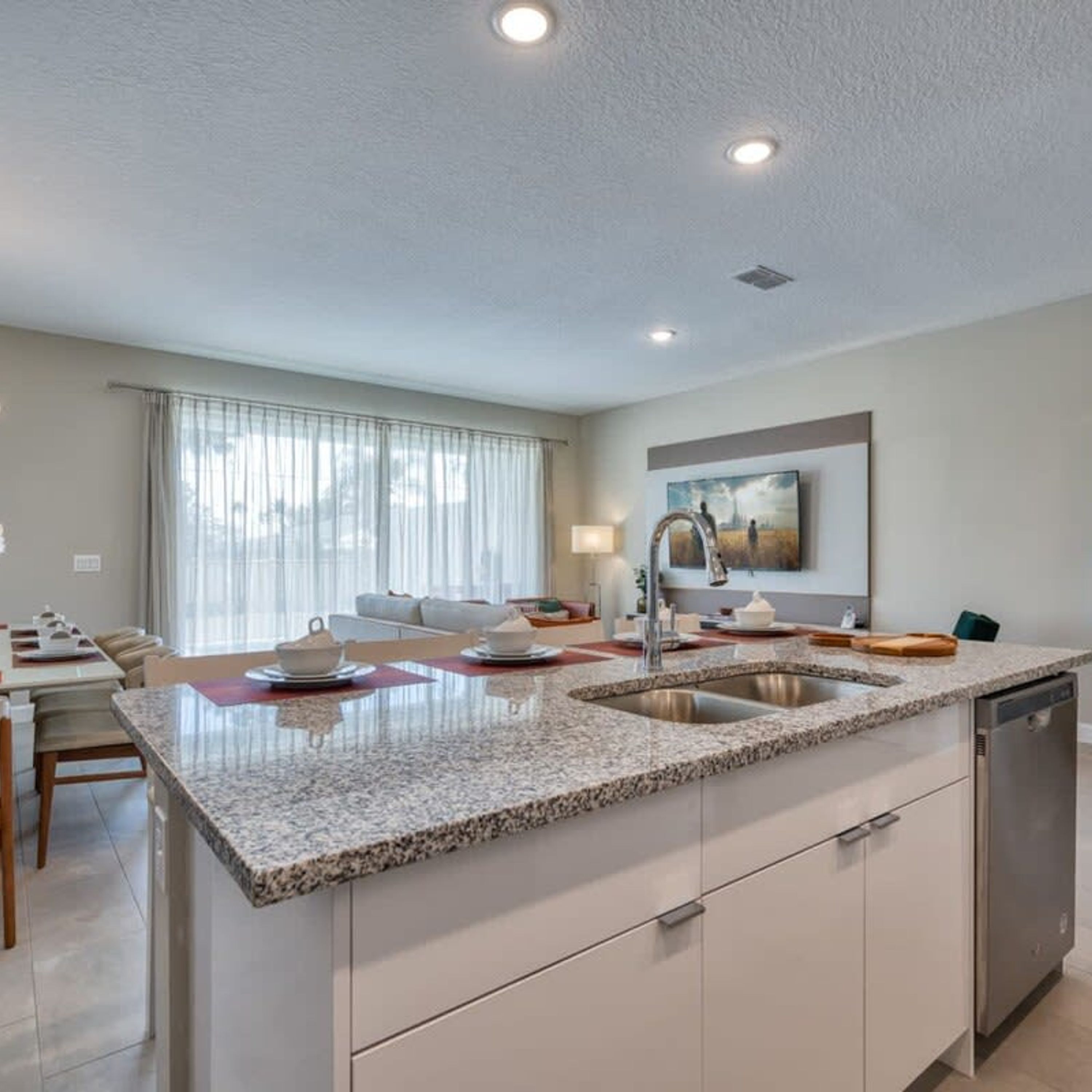 A modern kitchen with granite countertops, a double sink, and a dishwasher.