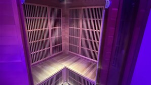 A room with a wooden slatted partition, a ceiling light, and a door.
