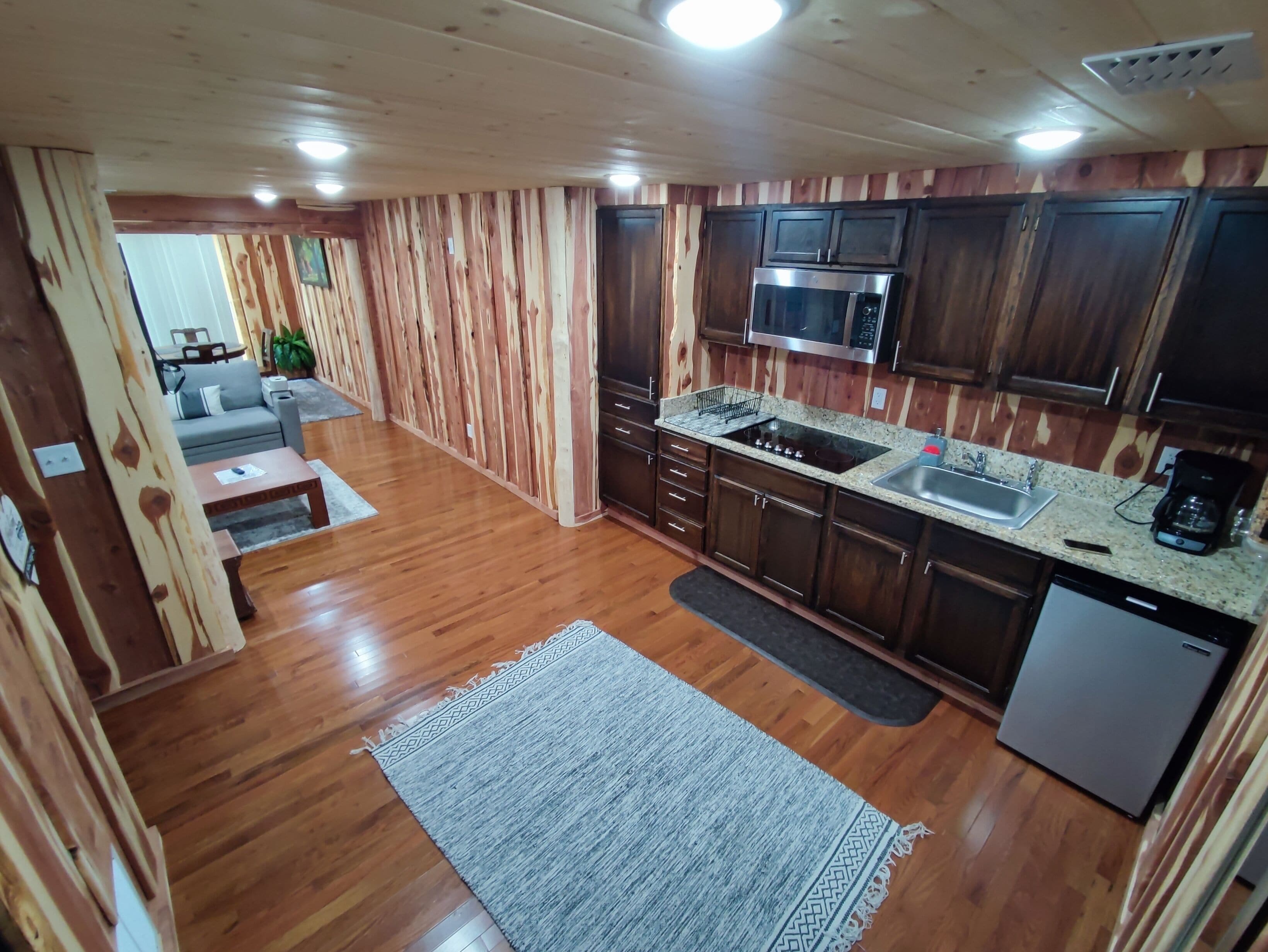 A modern kitchen with wooden cabinets, a stainless steel sink, and a built-in microwave.
