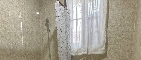 Une salle de bain avec une baignoire, des toilettes et une douche.