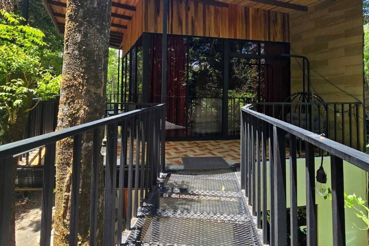 A covered outdoor staircase leading to a building with a wooden roof and metal railings.