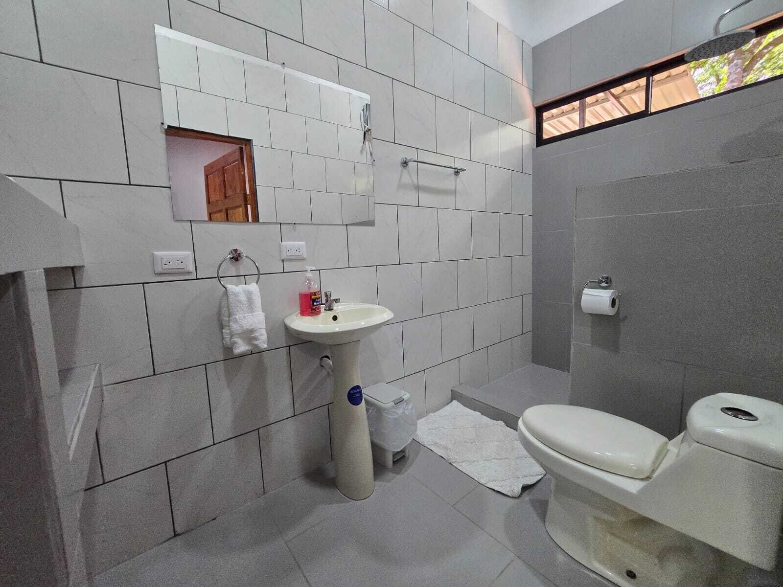 A bathroom with a sink, toilet, and shower area.