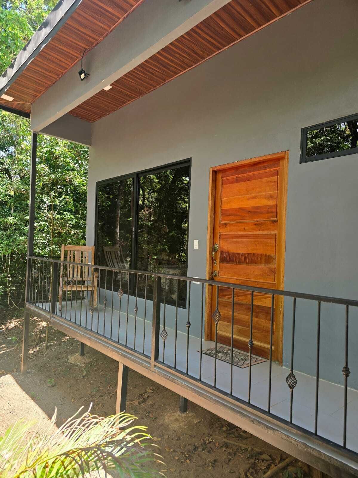 Une maison moderne dotée d’un balcon, de grandes fenêtres et d’une porte en bois.