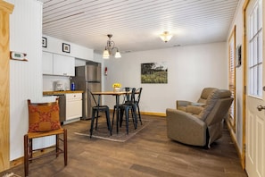 Un espace de vie compact comprenant une kitchenette, un coin repas et un espace détente.