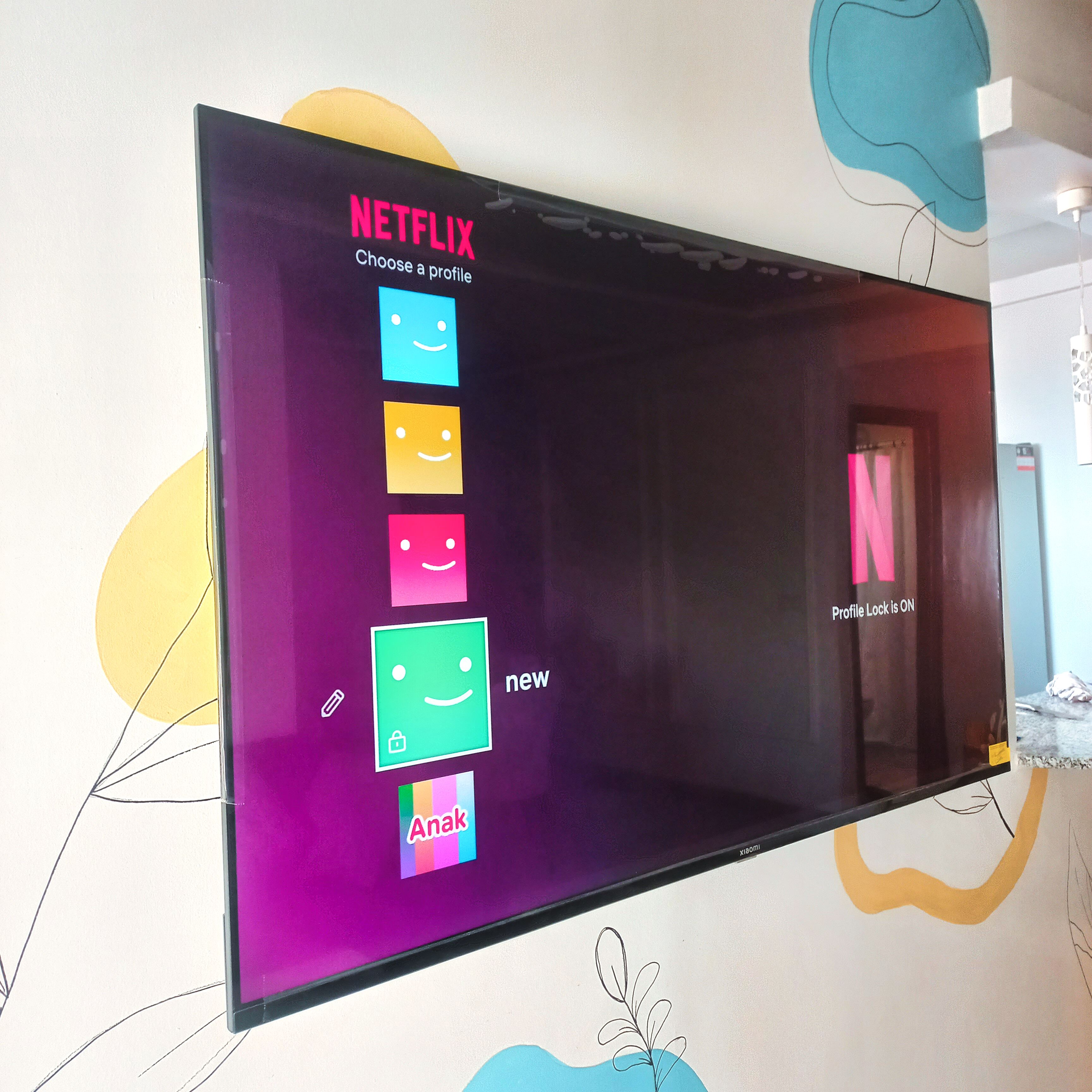 A television screen displaying the Netflix interface with profile options.