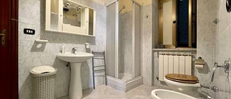 Une salle de bain équipée d’un lavabo, de toilettes, d’une douche et d’une baignoire.