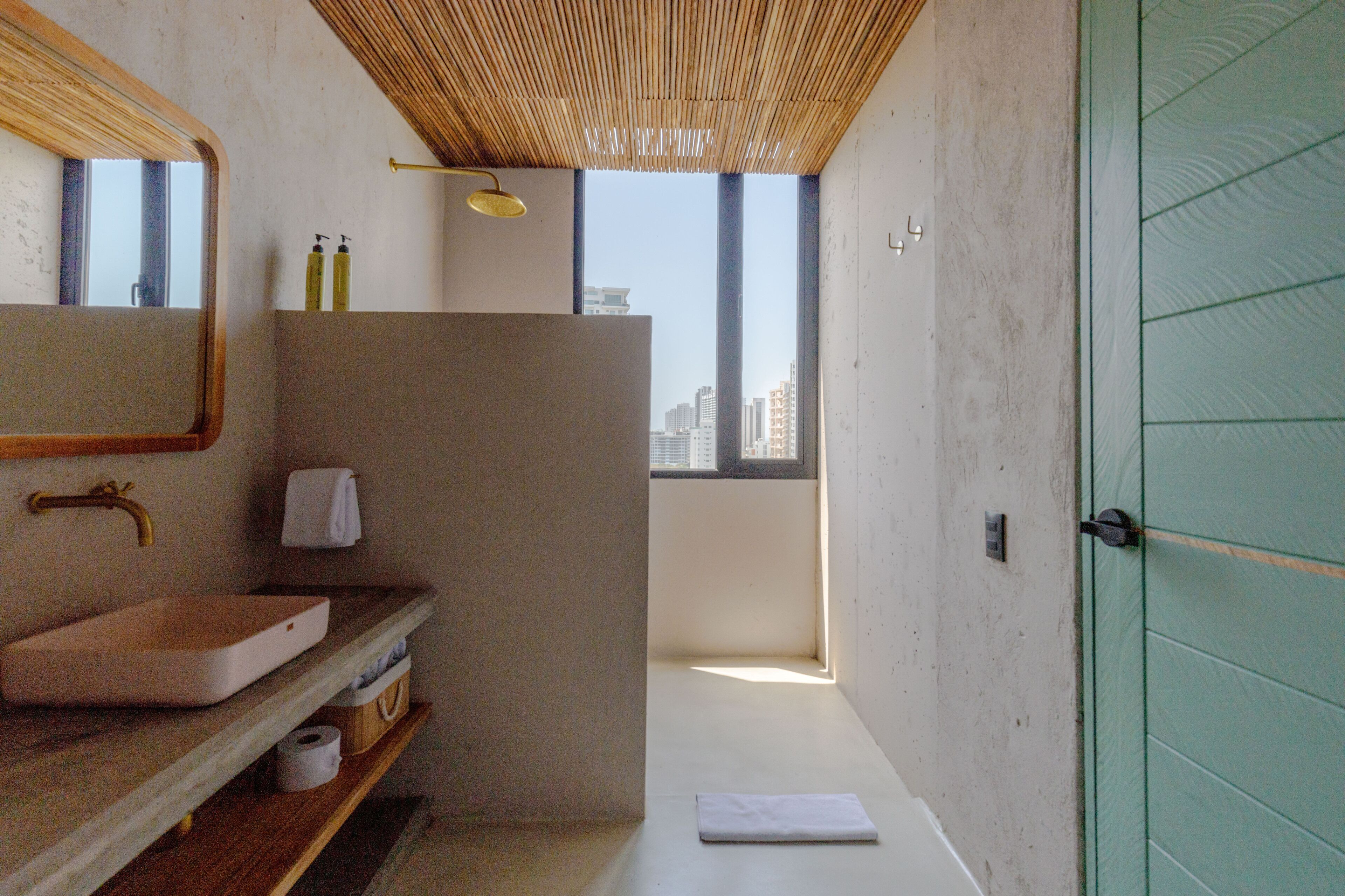 Une salle de bain moderne avec un grand miroir, un lavabo et un espace douche.