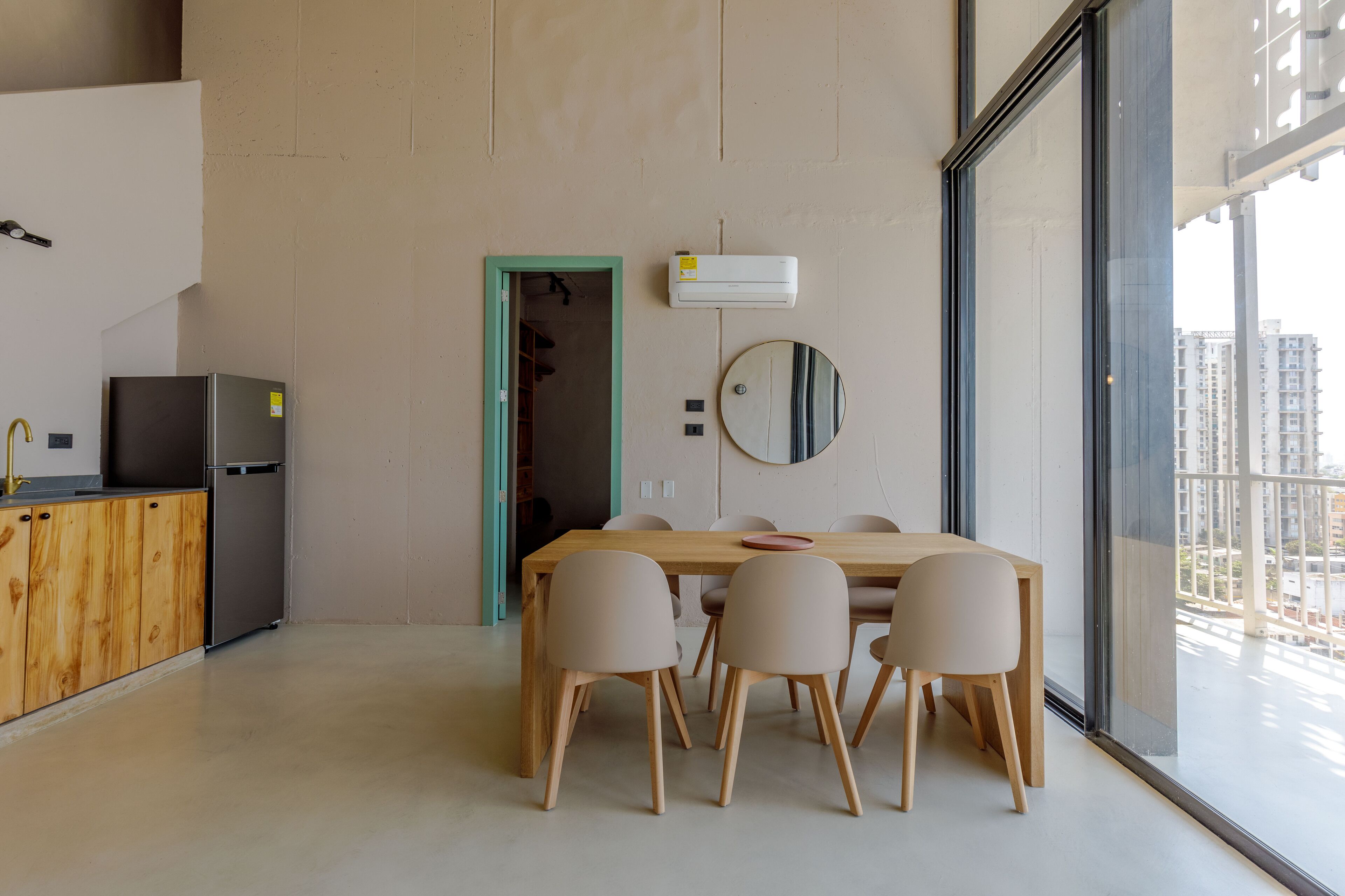 Una cocina moderna con refrigerador integrado, armarios de madera y un comedor con mesa y sillas.
