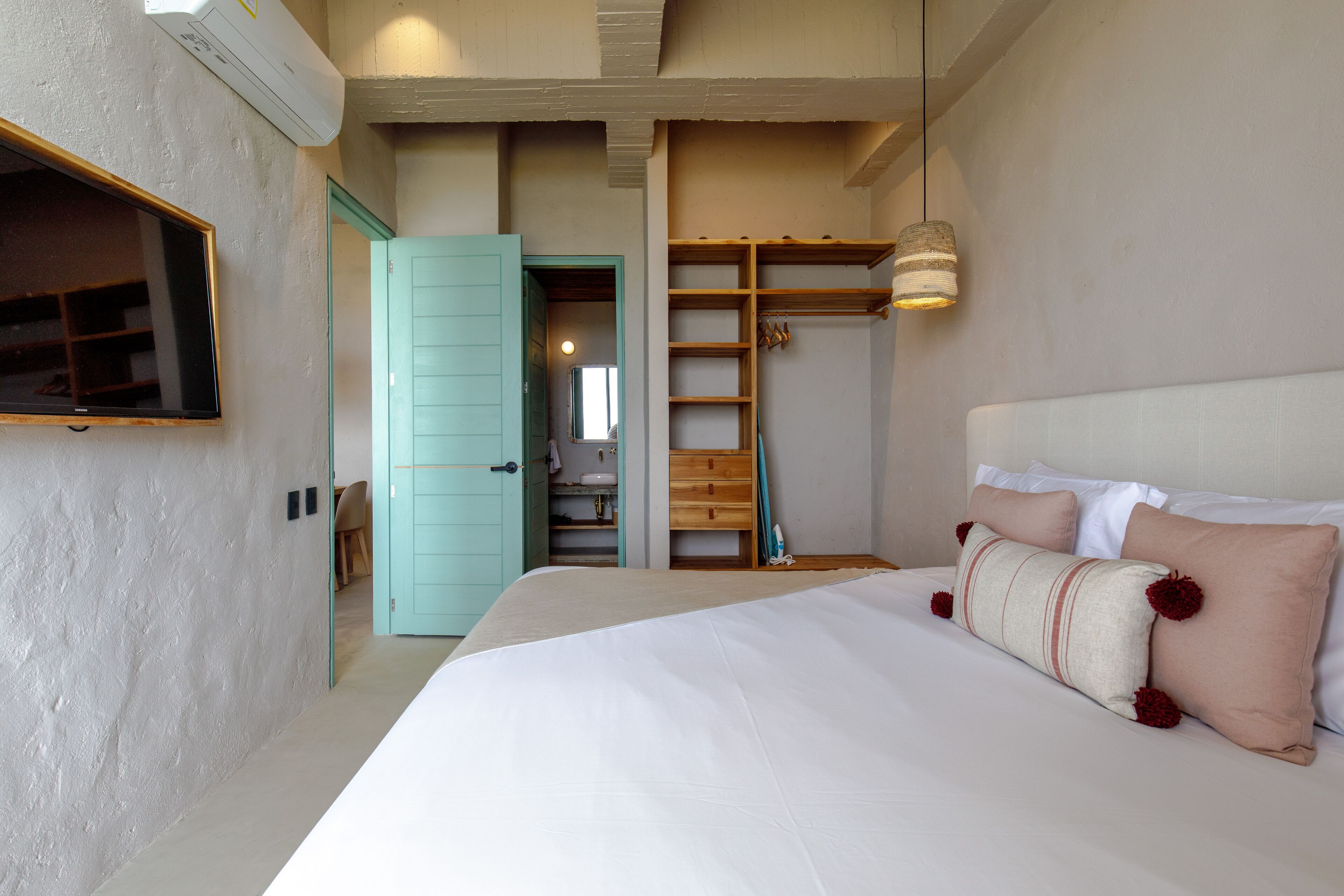 A bedroom with a large bed, a wardrobe, and a mirror.