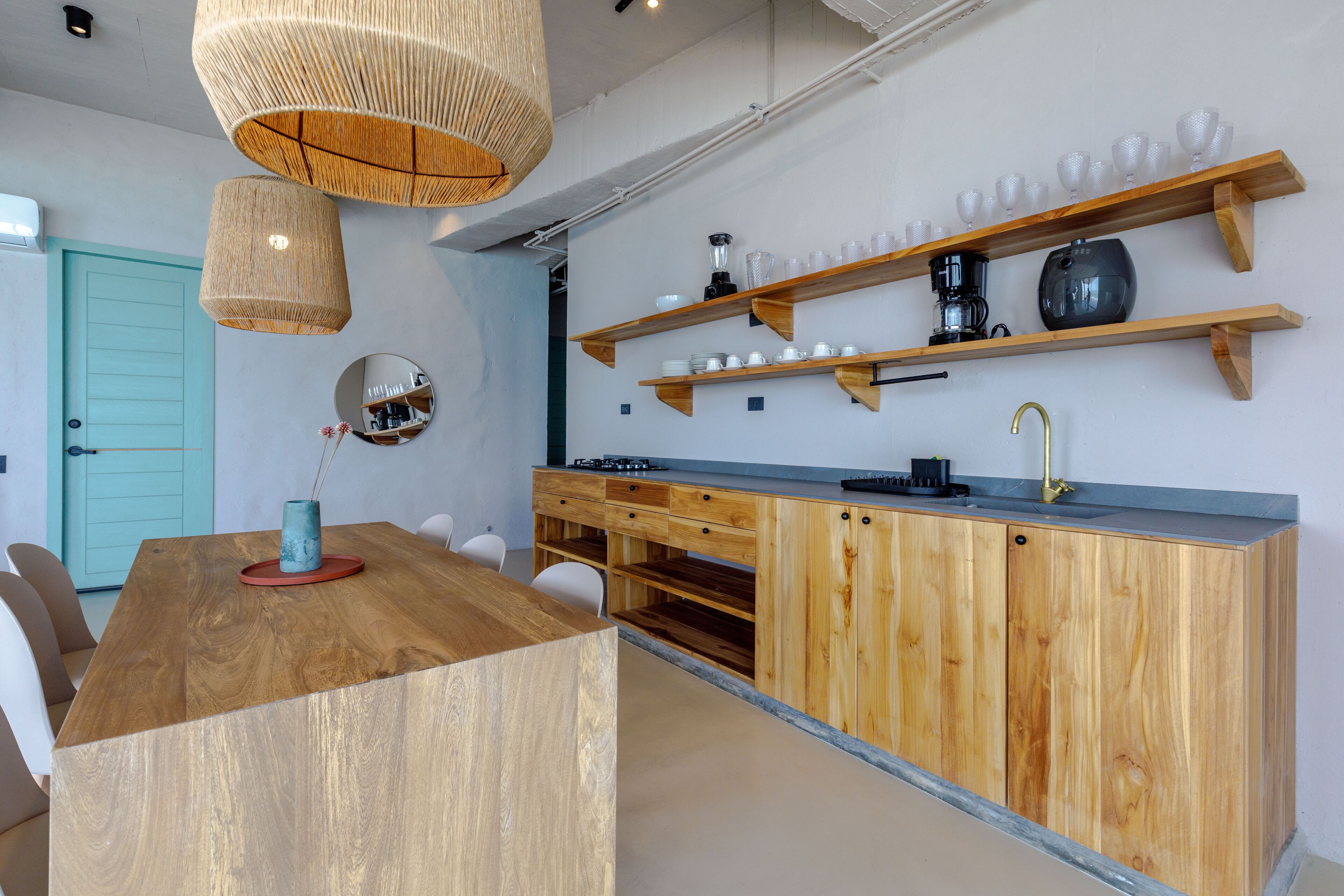 A modern kitchen with wooden cabinets, a central island, and hanging pendant lights.