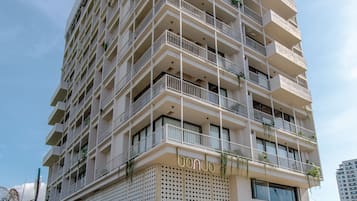 A multi-story hotel with balconies, a covered entrance, and a patterned facade.