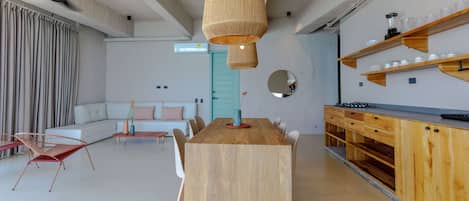 Una cocina moderna con una mesa de madera, sillas y una lámpara colgante.