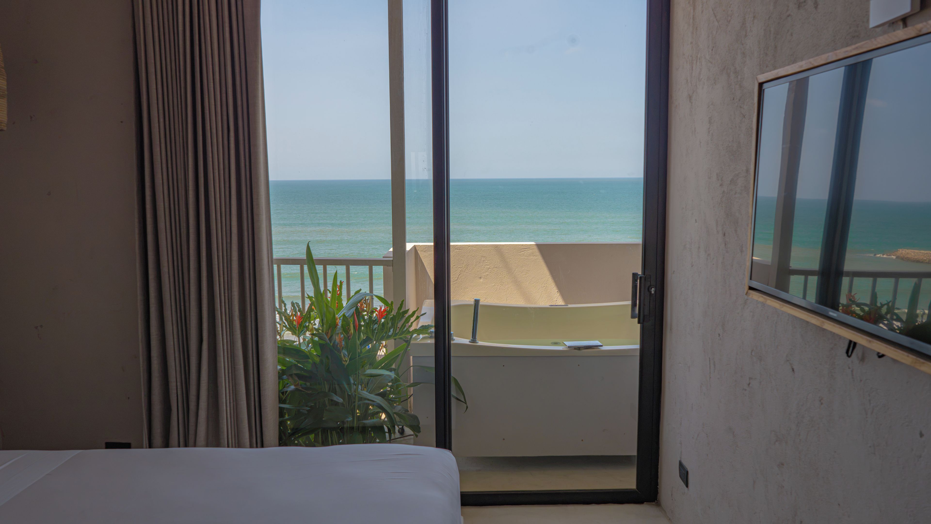 A hotel room with a balcony overlooking the sea.