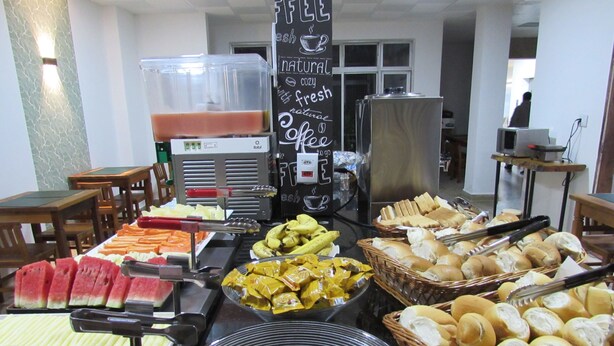 Un bufé con diversas opciones de comida, incluyendo frutas, panadería y pasteles.