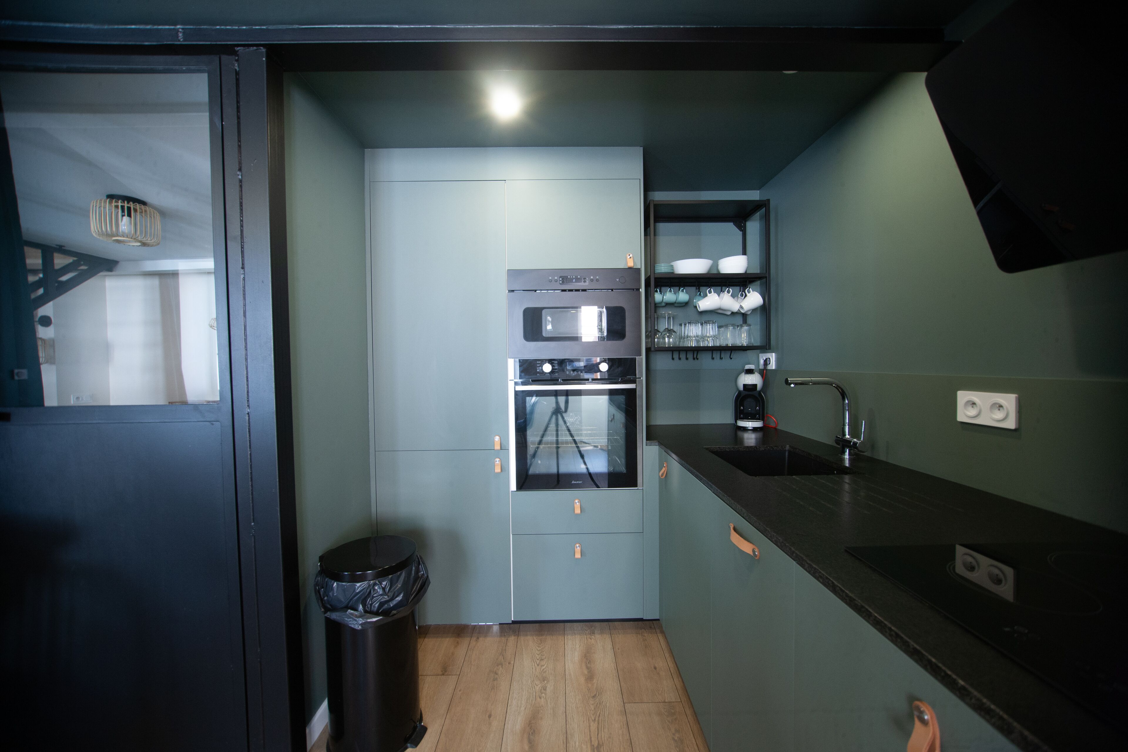 A compact kitchen with a microwave, oven, and sink.