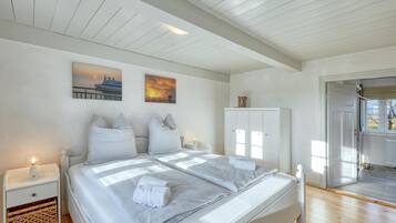Ein Schlafzimmer mit Bett, Nachttischen, einem Kleiderschrank und Bildern an der Wand.