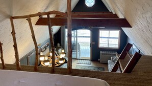 A high-ceilinged attic room with exposed wooden beams, a skylight, and a view of the outdoors. - Moose Cabin - Mountain Views, Hear Rushing River, Private, Pet Friendly (Fishtail)